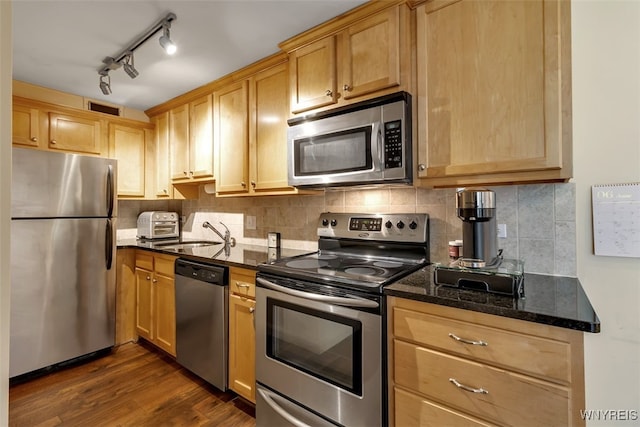 849 Delaware Ave Unit 205, Buffalo, NY 14209 - kitchen featuring stainless steel appliances, a sink, dark wood finished floors, dark stone countertops, and tasteful backsplash