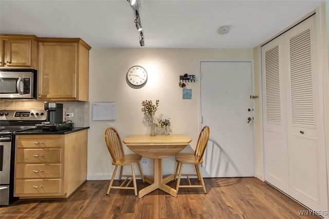 849 Delaware Ave Unit 205, Buffalo, NY 14209 - kitchen with stainless steel appliances, dark countertops, dark wood-style floors, backsplash, and baseboards