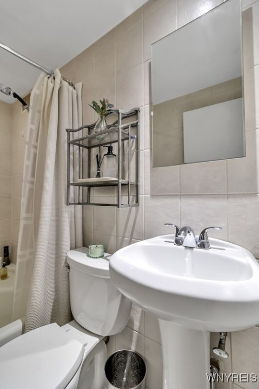 849 Delaware Ave Unit 205, Buffalo, NY 14209 - full bath with tile walls, toilet, tasteful backsplash, shower / bath combo, and a sink