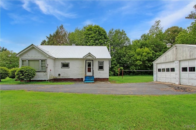 6341 Number Four Rd, Watson, NY 13367 - ranch-style house featuring entry steps, a front yard, metal roof, and a detached garage