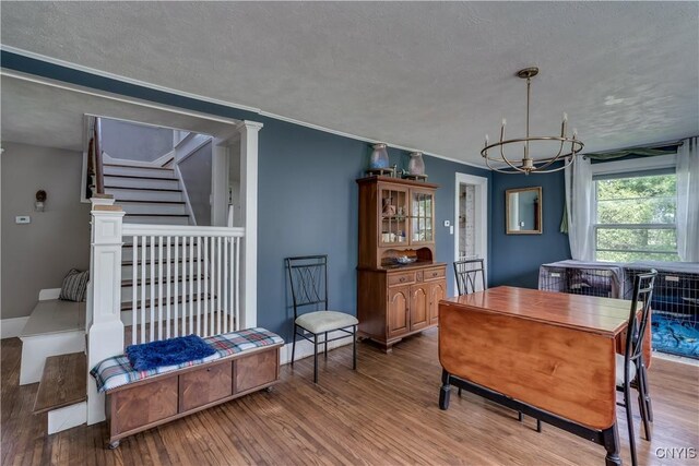 621 N Hycliff Dr, Watertown-City, NY 13601 - dining area featuring a chandelier, wood finished floors, a textured ceiling, and stairs