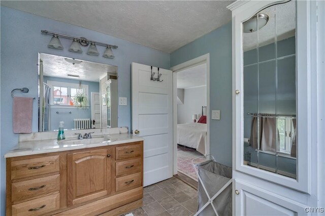 621 N Hycliff Dr, Watertown-City, NY 13601 - bathroom featuring radiator heating unit, vanity, ensuite bath, and a textured ceiling