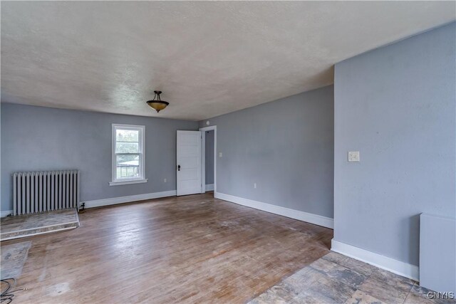 621 N Hycliff Dr, Watertown-City, NY 13601 - unfurnished living room with radiator, baseboards, and wood finished floors