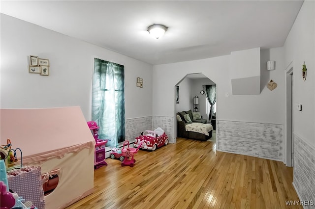 283 W Tupper St, Buffalo, NY 14201 - playroom featuring arched walkways, light wood-type flooring, and a wainscoted wall