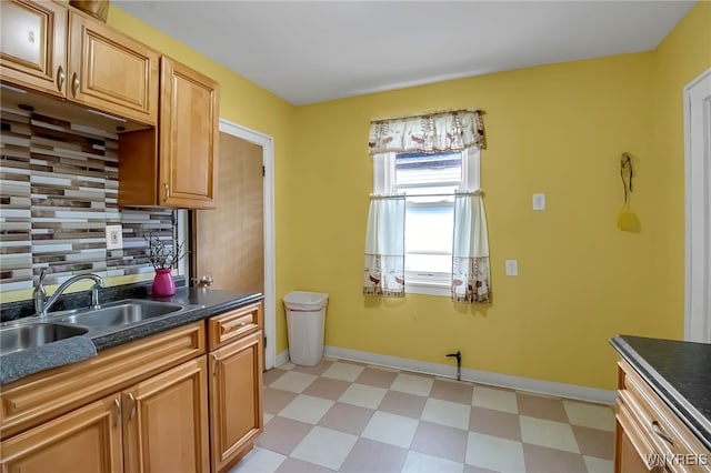283 W Tupper St, Buffalo, NY 14201 - kitchen with a sink, light flooring, dark countertops, decorative backsplash, and baseboards