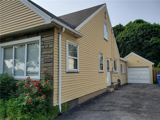 526 Winchester St, Rochester, NY 14615 - view of side of property featuring an outbuilding, driveway, and a shingled roof