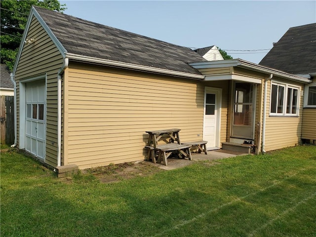526 Winchester St, Rochester, NY 14615 - back of property with entry steps, a shingled roof, a lawn, and an outbuilding