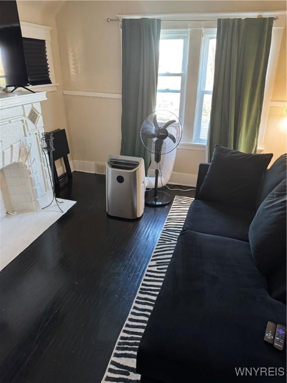 44 Freeman St, Buffalo, NY 14215 - living room featuring baseboards, dark wood-type flooring, and a fireplace