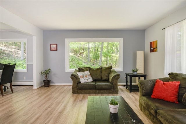 25 Highland Dr, Corning-City, NY 14830 - living area featuring a baseboard heating unit, plenty of natural light, light wood-style flooring, and baseboards