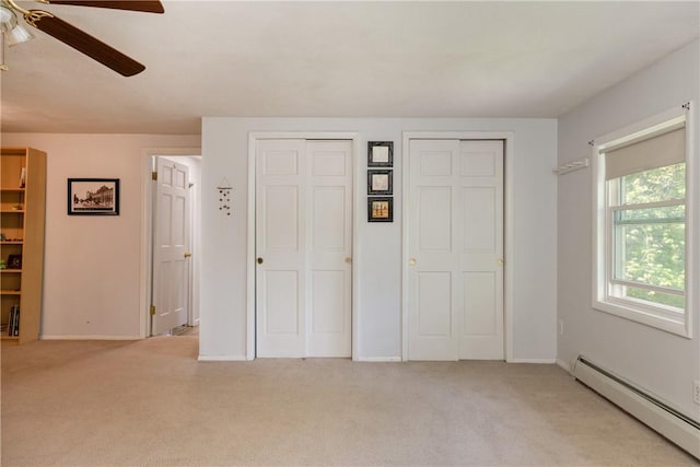 25 Highland Dr, Corning-City, NY 14830 - unfurnished bedroom featuring a baseboard radiator, light carpet, two closets, and ceiling fan