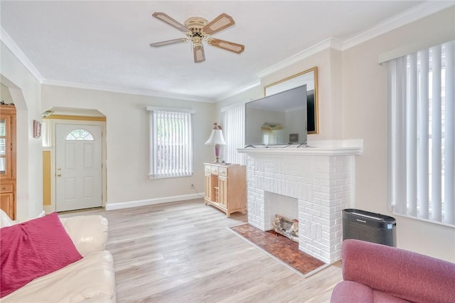 350 Colebourne Rd, Rochester, NY 14609 - living room with light wood-style floors, ornamental molding, ceiling fan, a brick fireplace, and arched walkways