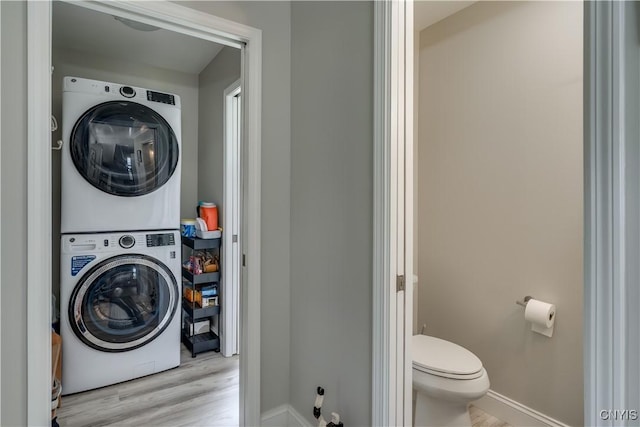 32160 State Route 12e, Cape Vincent, NY 13618 - washroom featuring stacked washer / drying machine, wood finished floors, and baseboards