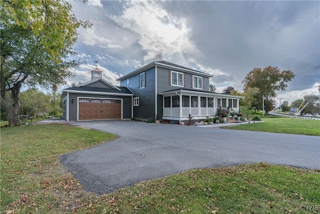 32160 State Route 12e, Cape Vincent, NY 13618 - view of front facade with a sunroom, driveway, a front yard, and a garage