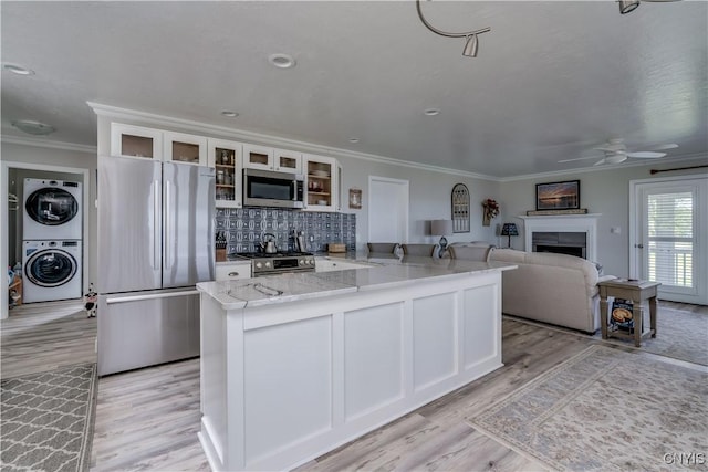32160 State Route 12e, Cape Vincent, NY 13618 - kitchen with stainless steel appliances, stacked washer / drying machine, ornamental molding, a peninsula, and ceiling fan