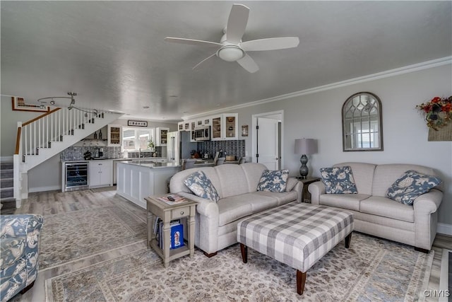 32160 State Route 12e, Cape Vincent, NY 13618 - living room featuring wine cooler, stairs, ornamental molding, a ceiling fan, and light wood-style floors