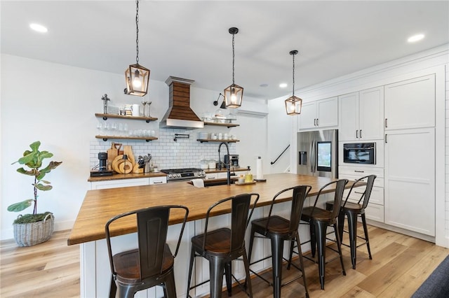 7698 Ridge Rd, Sodus, NY 14551 - kitchen featuring stainless steel appliances, custom range hood, backsplash, wooden counters, and recessed lighting
