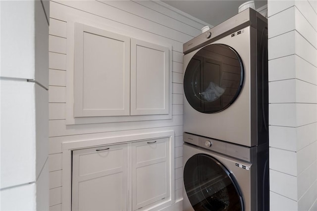 7698 Ridge Rd, Sodus, NY 14551 - laundry room featuring stacked washing machine and dryer and cabinet space