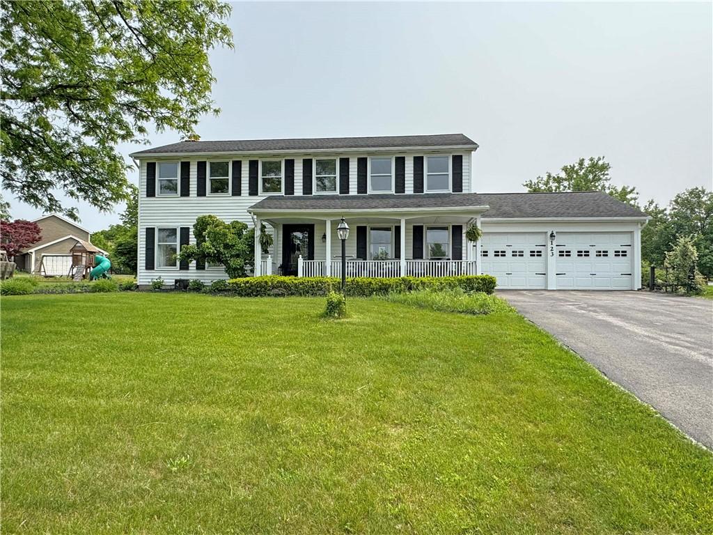 123 Brandywine Ln, Brighton, NY 14618 - colonial house featuring driveway, a garage, a porch, and a front yard