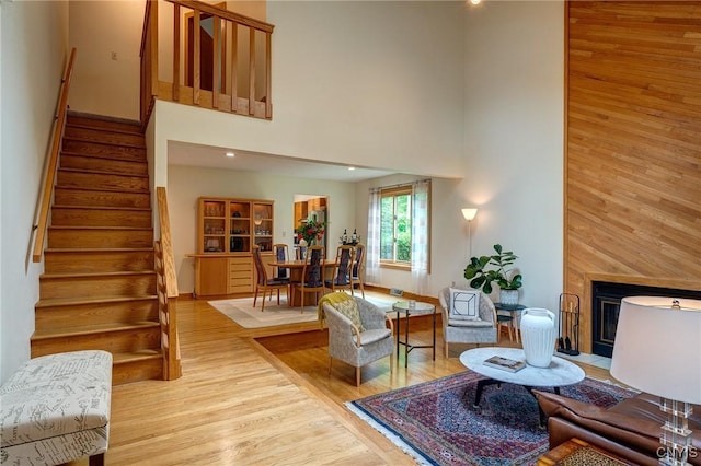 3502 Lightfoot Ln, Lysander, NY 13027 - living area featuring a high ceiling, stairway, a fireplace with flush hearth, and wood finished floors