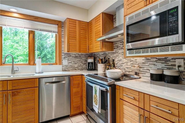 3502 Lightfoot Ln, Lysander, NY 13027 - kitchen with appliances with stainless steel finishes, a sink, wall chimney exhaust hood, tasteful backsplash, and brown cabinetry