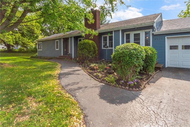 4411 Williamson Rd, Marion, NY 14505 - ranch-style house with a chimney, a front yard, driveway, and a garage