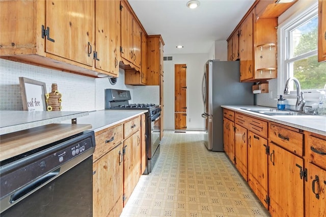 4411 Williamson Rd, Marion, NY 14505 - kitchen with appliances with stainless steel finishes, a sink, light countertops, brown cabinetry, and light flooring
