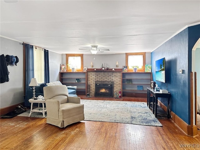 4 Park Rd W, Castile, NY 14427 - living room featuring ceiling fan, hardwood / wood-style floors, healthy amount of natural light, a brick fireplace, and ornamental molding