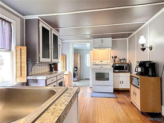 4 Park Rd W, Castile, NY 14427 - kitchen featuring white range with electric cooktop, stainless steel microwave, light wood-type flooring, healthy amount of natural light, and crown molding