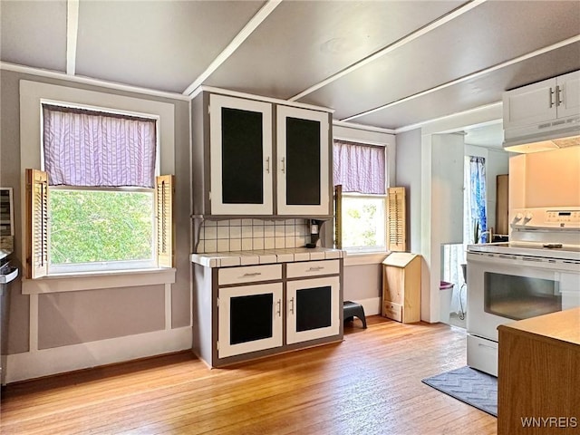 4 Park Rd W, Castile, NY 14427 - kitchen featuring electric stove, light wood finished floors, under cabinet range hood, glass insert cabinets, and tile counters