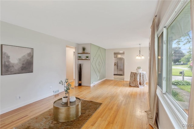 211 Fletcher Dr, Clay, NY 13212 - living room featuring light wood-style flooring, a chandelier, and baseboards