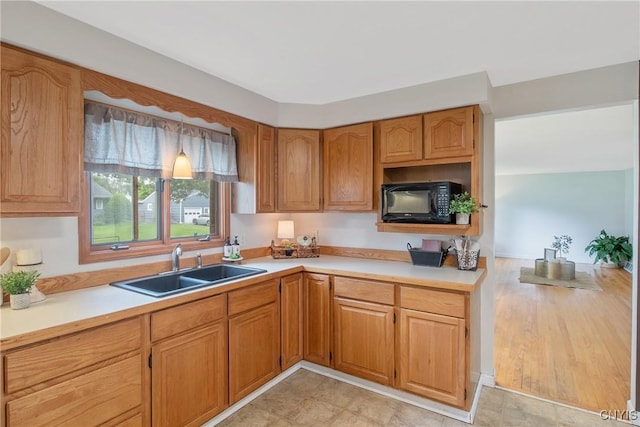 211 Fletcher Dr, Clay, NY 13212 - kitchen featuring black microwave, a sink, light countertops, and brown cabinetry