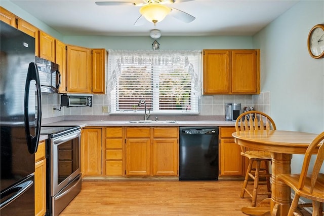 8 Harrier Cir, Henrietta, NY 14623 - kitchen featuring black appliances, a sink, light countertops, and light wood-style floors