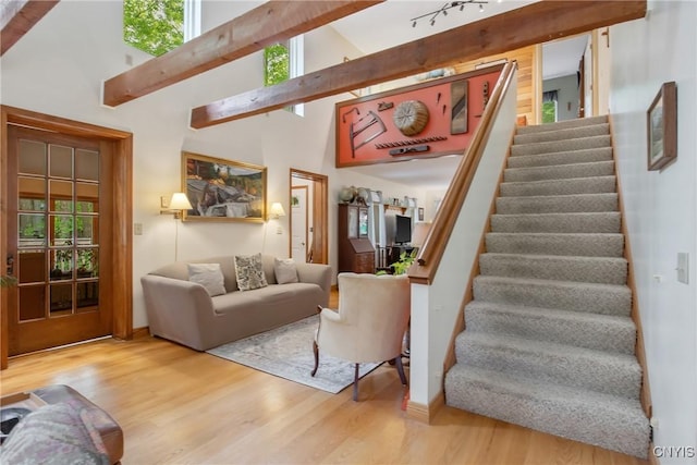 1388 Sky High Rd, Fabius, NY 13159 - living room with stairway, wood finished floors, beamed ceiling, healthy amount of natural light, and high vaulted ceiling