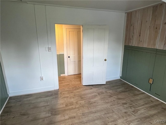 808 Fay, Bangor, NY 12966 - unfurnished bedroom featuring wood finished floors, baseboards, wooden walls, and crown molding