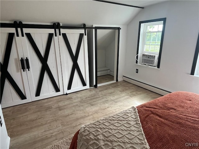 808 Fay, Bangor, NY 12966 - bedroom with lofted ceiling, a baseboard radiator, light wood-style flooring, cooling unit, and a barn door