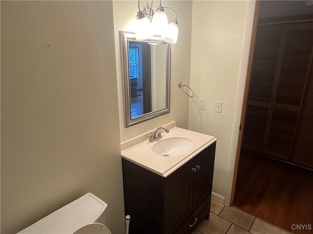 808 Fay, Bangor, NY 12966 - half bathroom featuring vanity, tile patterned flooring, toilet, and a chandelier