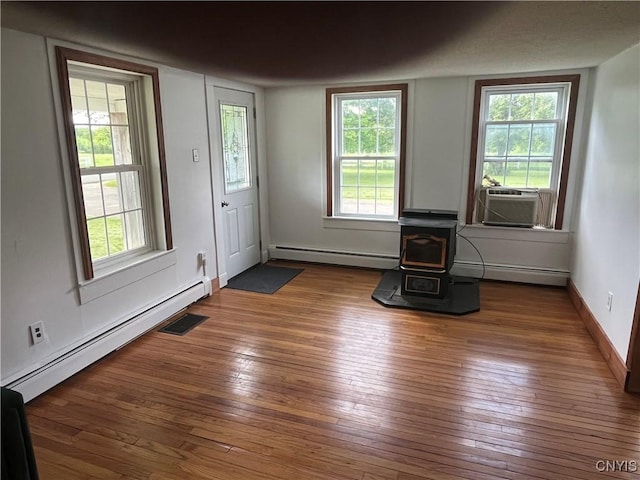 808 Fay, Bangor, NY 12966 - foyer with a baseboard heating unit, a wood stove, and hardwood / wood-style floors