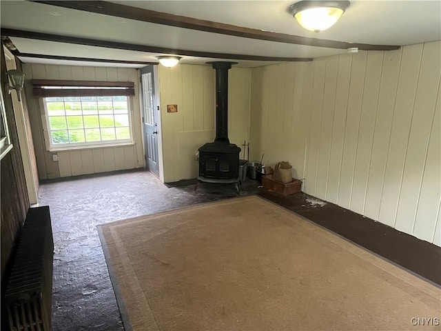 808 Fay, Bangor, NY 12966 - unfurnished living room with carpet flooring, a wood stove, and wood walls