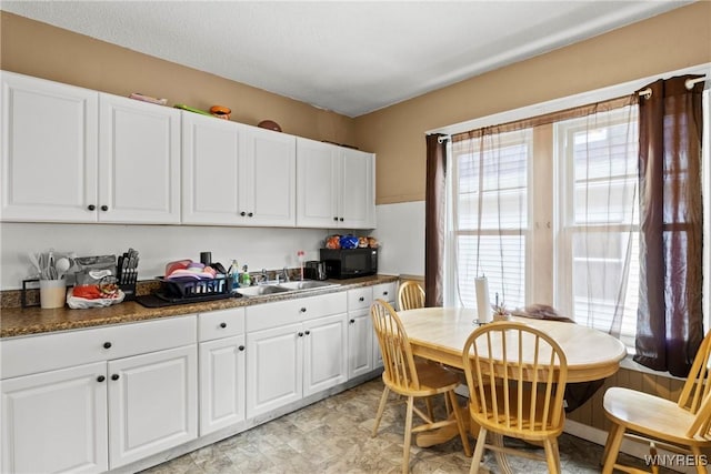 417 18th St, Niagara Falls, NY 14303 - kitchen with a sink, black microwave, and white cabinets