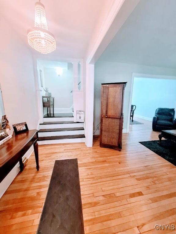 7 Genesee Ct, Utica, NY 13502 - corridor featuring stairway, hardwood / wood-style flooring, and a chandelier