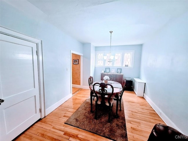 7 Genesee Ct, Utica, NY 13502 - dining room featuring a chandelier, light wood-style floors, and baseboards