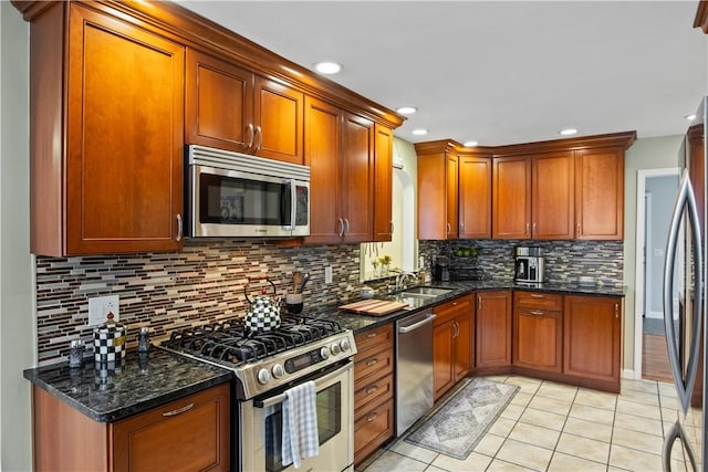 193 Floral Dr, Irondequoit, NY 14617 - kitchen featuring stainless steel appliances, a sink, backsplash, light tile patterned floors, and dark stone counters