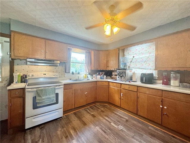 341 Grant St, Elmira-City, NY 14901 - kitchen with electric range, under cabinet range hood, a sink, light countertops, and dark wood finished floors