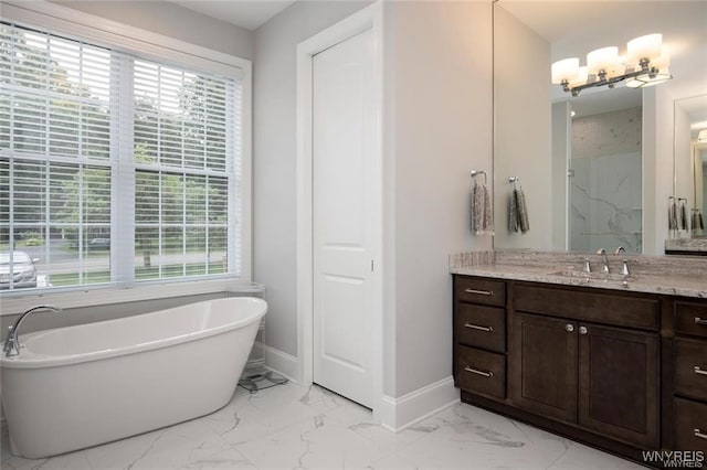 520 Paradise Rd, Amherst, NY 14051 - bathroom with marble look tiles, a freestanding tub, vanity, baseboards, and a marble finish shower