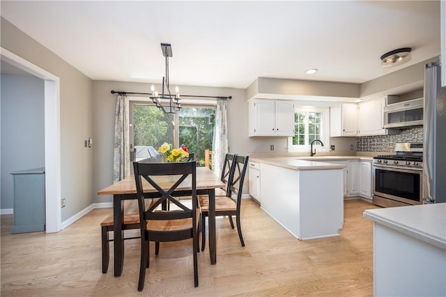 6 Barben Cir, Mendon, NY 14506 - kitchen featuring appliances with stainless steel finishes, white cabinetry, a chandelier, light countertops, and light wood-style floors