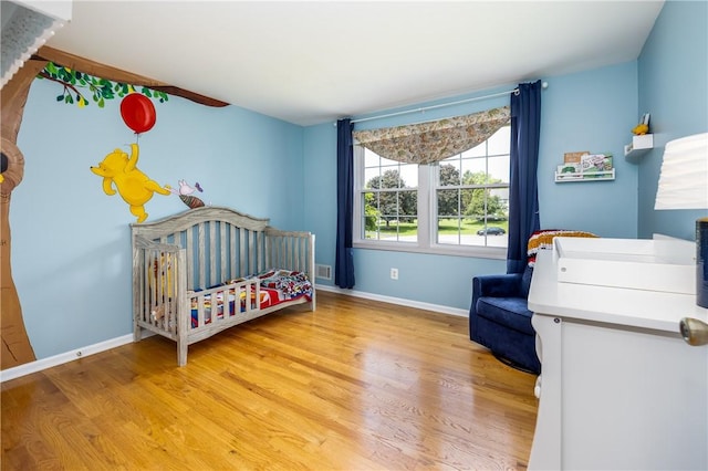 6 Barben Cir, Mendon, NY 14506 - bedroom featuring light wood finished floors, baseboards, and a crib
