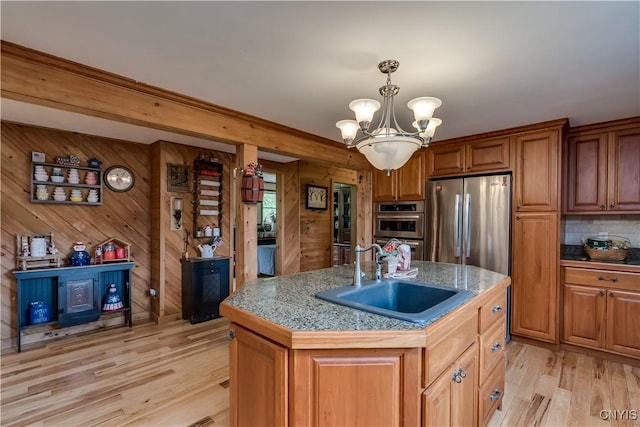 9758 E Rd, Denmark, NY 13367 - kitchen featuring a sink, appliances with stainless steel finishes, a chandelier, light wood-type flooring, and brown cabinets