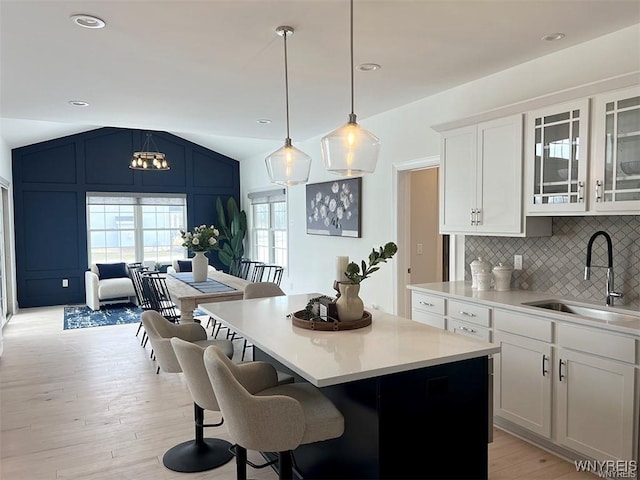 6401 Ward, Wheatfield, NY 14132 - kitchen featuring a sink, vaulted ceiling, a breakfast bar area, a center island, and decorative backsplash