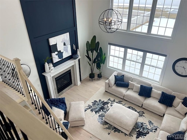 6401 Ward, Wheatfield, NY 14132 - living room with a chandelier, wood finished floors, a tile fireplace, a high ceiling, and baseboards