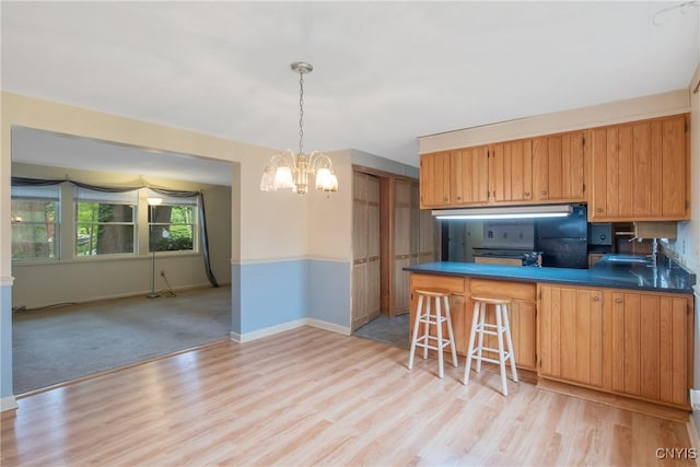3643 Armstrong Rd, Camillus, NY 13209 - kitchen featuring a chandelier, a sink, light wood finished floors, baseboards, and dark countertops